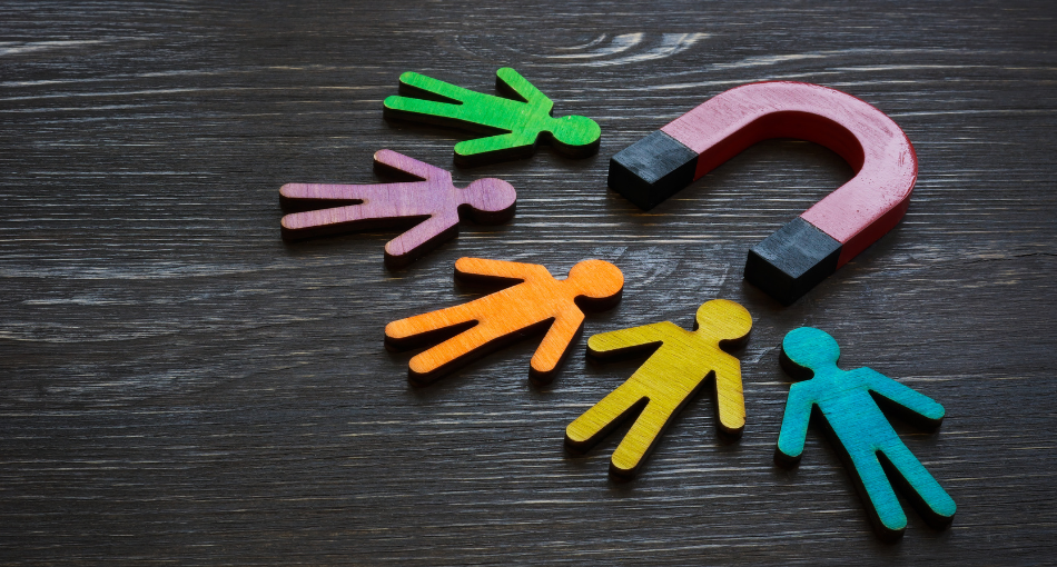 A magnet attracts colorful figurines of stick-figure people.