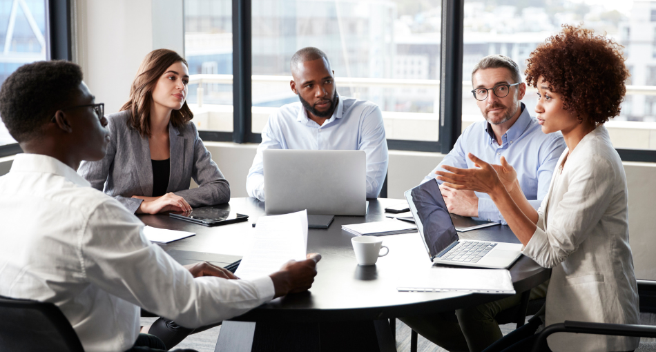 Teammates sit around a conference table talking about customer concerns.