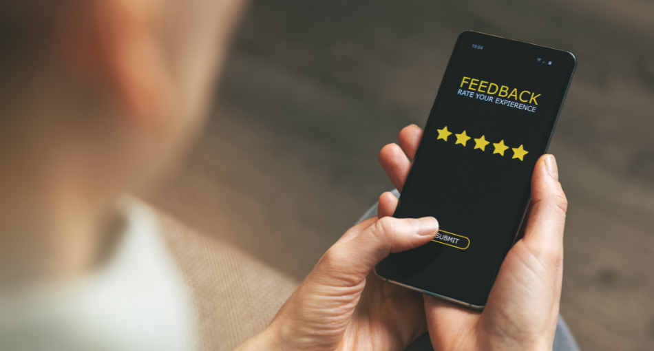 Person holds mobile phone to submit product feedback survey.